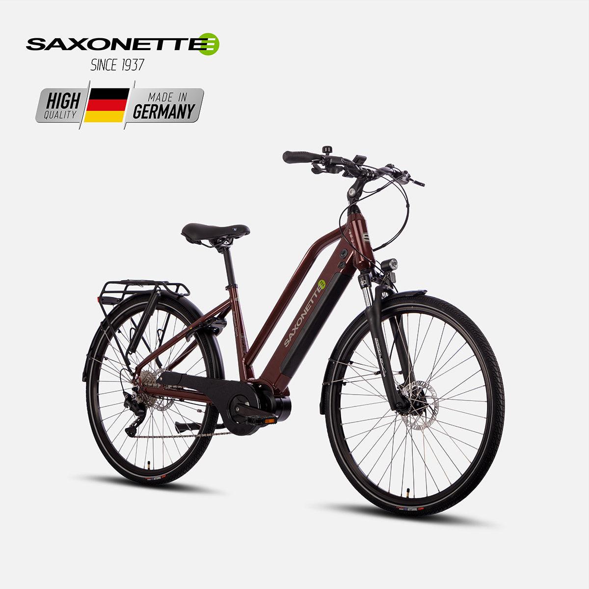 Schrägansicht: SAXONETTE Premium Sport Trapez in Bordeaux, Mittelmotor, integrierter Akku im Unterrohr, Scheibenbremsen und Gepäckträger.